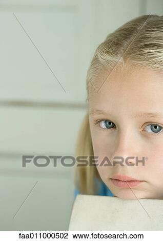 Girl resting head on edge of book, looking at camera View Large Photo Image Stock Image - Girl resting head on edge of book, looking at camera. Fotosearch