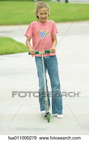 Girl riding push scooter View Large Photo Image Stock Photo - Girl riding push scooter. Fotosearch