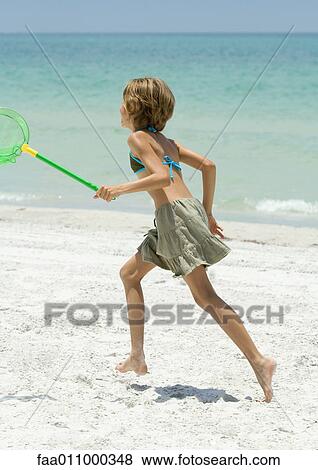Girl running with fishing net on beach View Large Photo Image Stock Photo - Girl running with fishing net on beach. Fotosearch