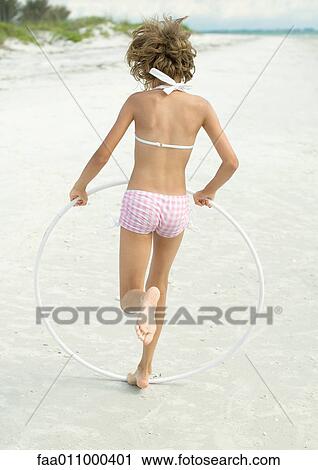 Girl running with hoola hoop on beach View Large Photo Image Stock Image - Girl running with hoola hoop on beach. Fotosearch