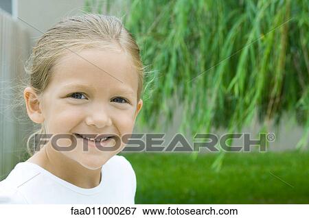 Girl smiling in backyard, portrait View Large Photo Image Stock Photo - Girl smiling in backyard, portrait. Fotosearch