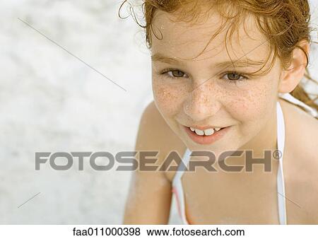 Stock Photo - Girl smiling on beach, portrait. Fotosearch