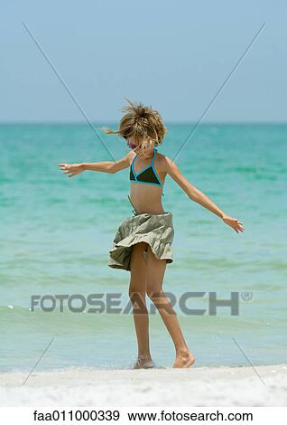 Girl standing in wind on beach View Large Photo Image Stock Photo - Girl standing in wind on beach. Fotosearch