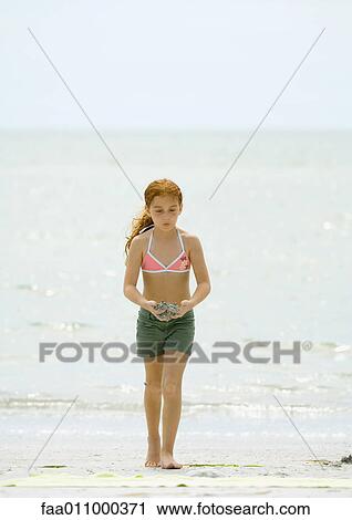 Girl walking on beach, carrying sand in hands View Large Photo Image Stock Image - Girl walking on beach, carrying sand in hands. Fotosearch