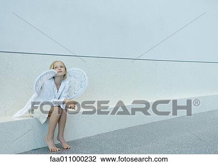 Stock Image - Girl wearing angel wings. Fotosearch