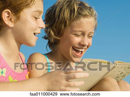 Stock Photo - Girls in swimsuits reading book together. Fotosearch