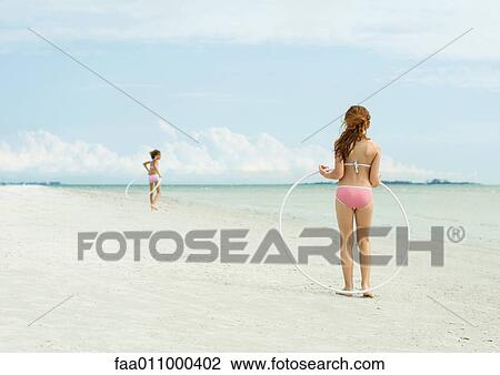 Girls playing with hoola hoops on beach View Large Photo Image Stock Image - Girls playing with hoola hoops on beach. Fotosearch