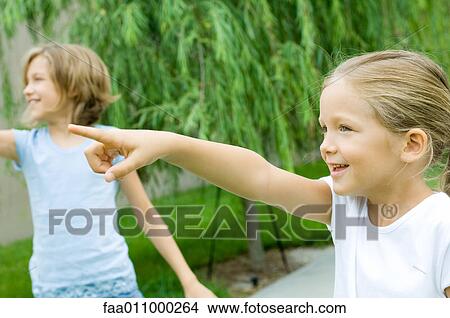Girls pointing and looking out of frame View Large Photo Image Picture - Girls pointing and looking out of frame. Fotosearch