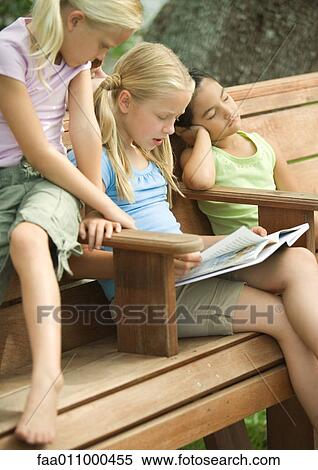 Girls reading book together View Large Photo Image Stock Photography - Girls reading book together. Fotosearch