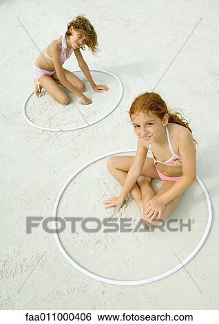Girls sitting in rings, playing in sand on beach View Large Photo Image Stock Photograph - Girls sitting in rings, playing in sand on beach. Fotosearch