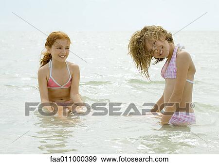 Girls sitting in shallow water View Large Photo Image Stock Photo - Girls sitting in shallow water. Fotosearch