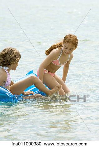 Girls sitting on air mattress together View Large Photo Image Stock Image - Girls sitting on air mattress together. Fotosearch