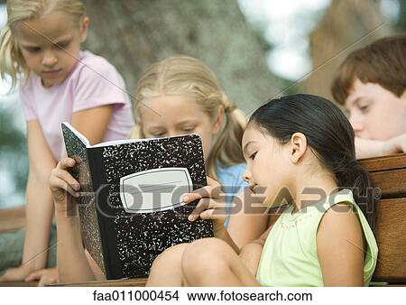 Group of children looking at notebook together View Large Photo Image Picture - Group of children looking at notebook together. Fotosearch