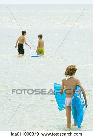 Kids playing in water at the beach View Large Photo Image Stock Photo - Kids playing in water at the beach. Fotosearch
