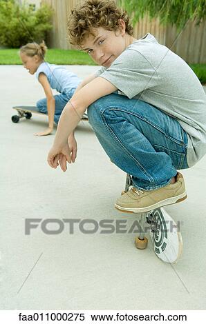 Kids playing on skateboards View Large Photo Image Stock Photography - Kids playing on skateboards. Fotosearch