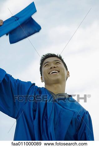 Male graduate taking off cap View Large Photo Image Stock Photo - Male graduate taking off cap. Fotosearch