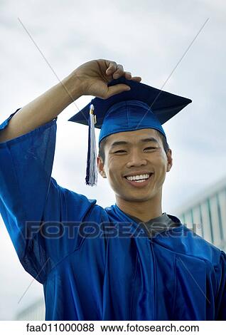 Male graduate with hand on cap View Large Photo Image Stock Photo - Male graduate with hand on cap. Fotosearch