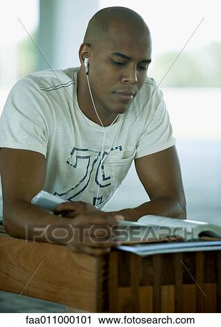 Male student studying and listening to earphones View Large Photo Image Stock Image - Male student studying and listening to earphones. Fotosearch
