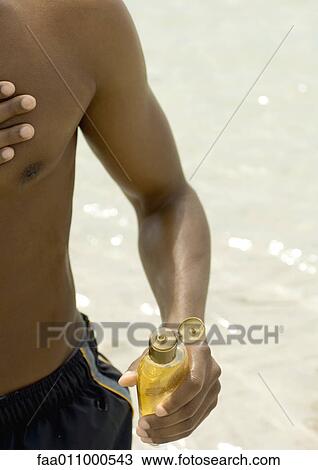 Stock Image - Man applying sunscreen. Fotosearch