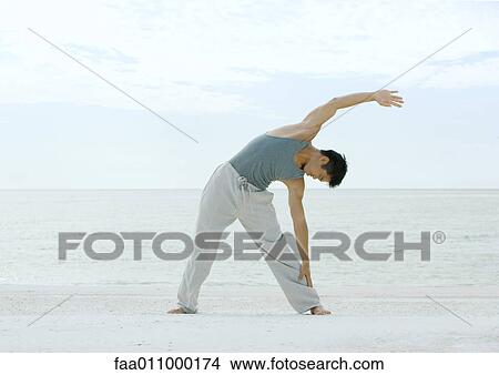 Man doing side stretch on beach View Large Photo Image Picture - Man doing side stretch on beach. Fotosearch