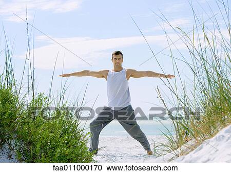 Man doing stretches on beach View Large Photo Image Stock Image - Man doing stretches on beach. Fotosearch