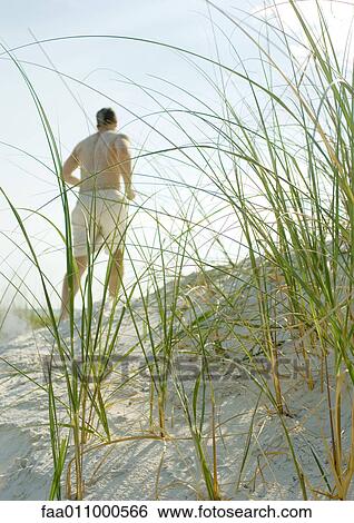 Stock Photograph - Man jogging in dunes. Fotosearch