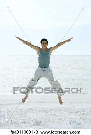 Man jumping spreadeagled on beach View Large Photo Image Stock Photo - Man jumping spreadeagled on beach. Fotosearch