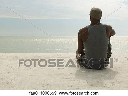 Man looking at view on beach View Large Photo Image Stock Photo - Man looking at view on beach. Fotosearch
