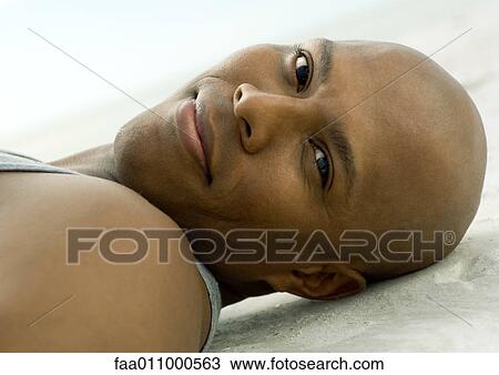 Stock Image - Man lying on sand. Fotosearch