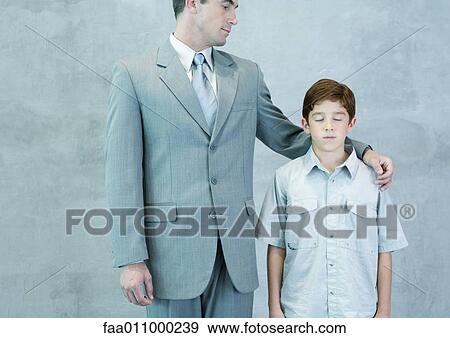 Man putting arm around boy with closed eyes View Large Photo Image Stock Photo - Man putting arm around boy with closed eyes. Fotosearch