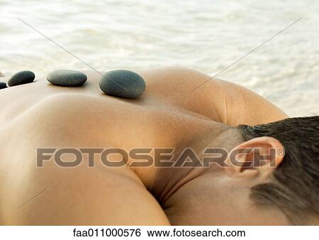Man receiving hot stone therapy View Large Photo Image Stock Photograph - Man receiving hot stone therapy. Fotosearch
