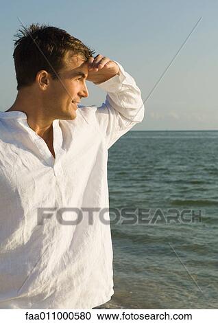 Man shading eyes, looking at sea View Large Photo Image Stock Image - Man shading eyes, looking at sea. Fotosearch
