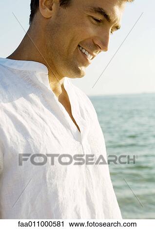 Man smiling, sea in background View Large Photo Image Stock Image - Man smiling, sea in background. Fotosearch