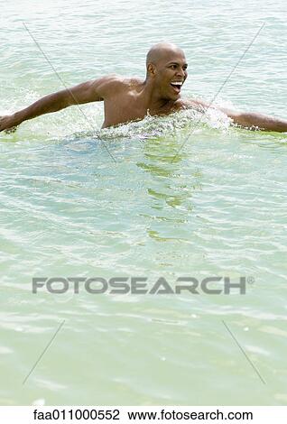 Stock Image - Man standing in water. Fotosearch