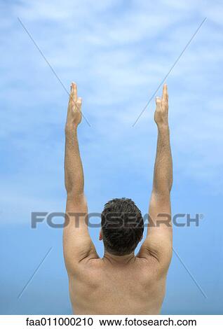 Man with arms raised, rear view View Large Photo Image Stock Image - Man with arms raised, rear view. Fotosearch