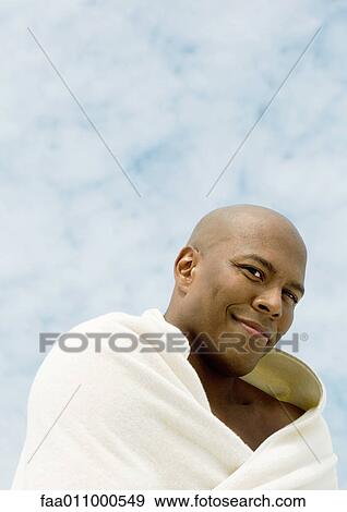 Man wrapped in towel, sky in background View Large Photo Image Stock Photo - Man wrapped in towel, sky in background. Fotosearch