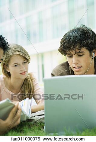 Stock Photograph - Students studying together, on grass. Fotosearch