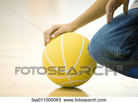 Teen boy crouching, holding basketball, close-up of hand on ball and knee View Large Photo Image Stock Image - Teen boy crouching, holding basketball, close-up of hand on ball and knee. Fotosearch