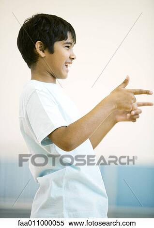 Teen boy pointing with both hands, smiling View Large Photo Image Stock Photography - Teen boy pointing with both hands, smiling. Fotosearch