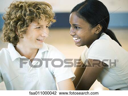 Teen couple smiling at each other View Large Photo Image Stock Image - Teen couple smiling at each other. Fotosearch