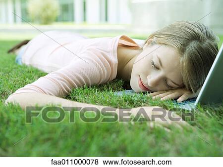 Teen girl sleeping with head on laptop, lying in grass View Large Photo Image Stock Photo - Teen girl sleeping with head on laptop, lying in grass. Fotosearch