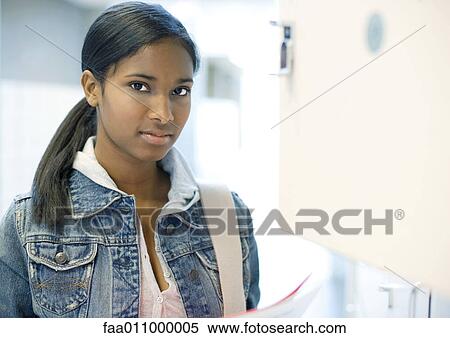 Teen girl standing by locker View Large Photo Image Stock Photography - Teen girl standing by locker. Fotosearch