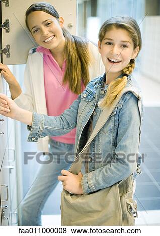 Teen girls standing by lockers View Large Photo Image Stock Photo - Teen girls standing by lockers. Fotosearch