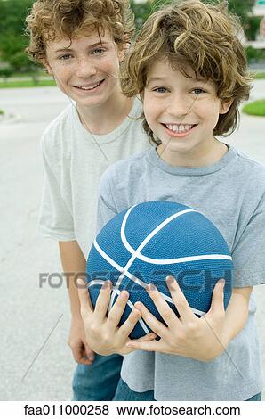 Two boys, one holding basketball, portrait View Large Photo Image Stock Photo - Two boys, one holding basketball, portrait. Fotosearch