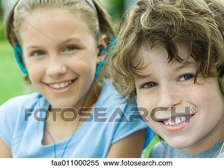 Two children smiling, one wearing earphones View Large Photo Image Stock Photography - Two children smiling, one wearing earphones. Fotosearch