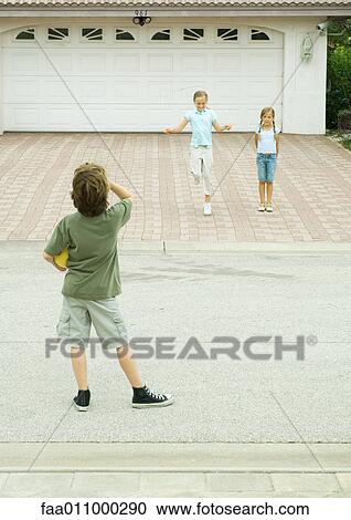Two girls playing in driveway while boy watches from street, hoolding ball View Large Photo Image Stock Image - Two girls playing in driveway while boy watches from street, hoolding ball. Fotosearch