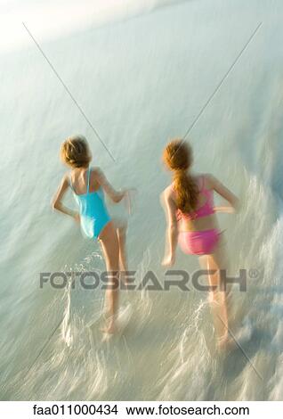 Two girls running in surf View Large Photo Image Picture - Two girls running in surf. Fotosearch