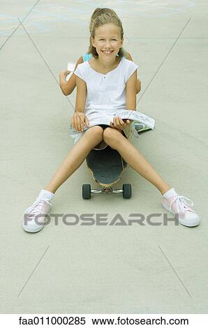 Two girls sitting back to back on skateboard, reading View Large Photo Image Stock Photography - Two girls sitting back to back on skateboard, reading. Fotosearch
