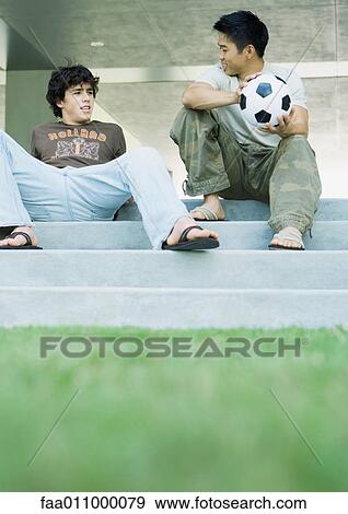 Two male college students sitting on steps, talking View Large Photo Image Stock Photo - Two male college students sitting on steps, talking. Fotosearch