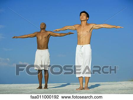 Two men doing relaxation exercises on the beach View Large Photo Image Stock Image - Two men doing relaxation exercises on the beach. Fotosearch